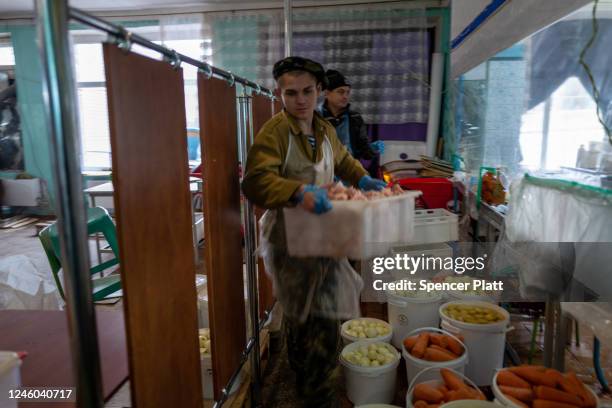 Volunteers with Myrne Nebo prepare meals for residents at a closed school in the town of Kupiansk which has experienced regular shelling from the...