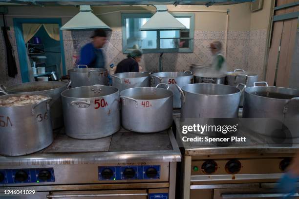 Volunteers with Myrne Nebo prepare meals for residents at a closed school in the town of Kupiansk which has experienced regular shelling from the...