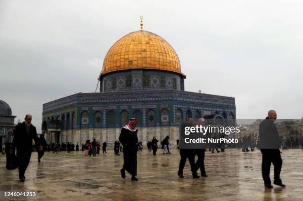 Worshippers gather next to the Dome of the Rock Mosque for Friday prayers on a cold, rainy day at the Al-Aqsa Mosque compound in the Old City of...