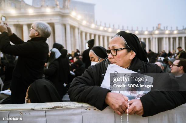 Nun is seen holding the newspaper "L'Osservatore Romano". Pope Francis held a funeral ceremony for his predecessor, Pope Benedict XVI , who resigned...