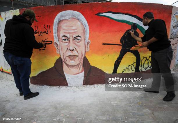 Artists paint a mural in Gaza City dedicated to Palestinian prisoner Karim Younes, who was released from Israeli prisons after spending 40 years.