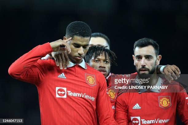 Manchester United's English striker Marcus Rashford celebrates with teammates after scoring their third goal from the penalty spot during the English...