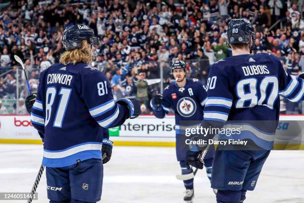 Kyle Connor, Mark Scheifele and Pierre-Luc Dubois of the Winnipeg Jets celebrate a third period goal against the Tampa Bay Lightning at the Canada...