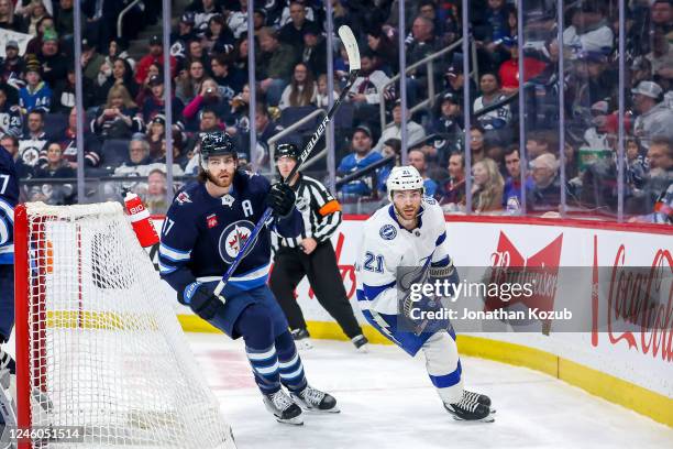 Adam Lowry of the Winnipeg Jets and Brayden Point of the Tampa Bay Lightning follow the play around the net during first period action at the Canada...