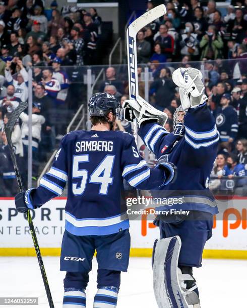 Goaltender Connor Hellebuyck of the Winnipeg Jets celebrates with teammate Dylan Samberg following a 4-2 victory over the Tampa Bay Lightning at the...