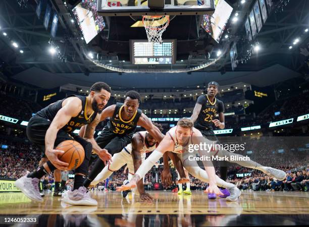 Fred VanVleet, Christian Koloko, and Chris Boucher of the Toronto Raptors battle for the ball with Isaiah Hartenstein and Mitchell Robinson of the...