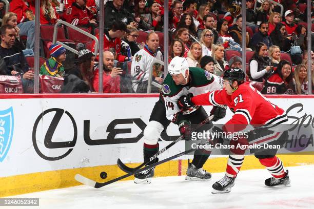 Zack Kassian of the Arizona Coyotes and Ian Mitchell of the Chicago Blackhawks work to get the puck during the third period at United Center on...