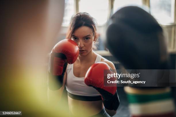 female boxer training with her male coach in gym - boxing trainer stock pictures, royalty-free photos & images