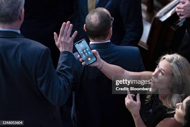 Representative Marjorie Taylor Greene, a Republican from Georgia, holds her smart phone with former US President Donald Trump on the line, as...