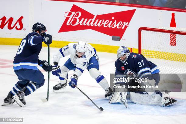 Anthony Cirelli of the Tampa Bay Lightning takes a back-handed shot on goaltender Connor Hellebuyck of the Winnipeg Jets during third period action...