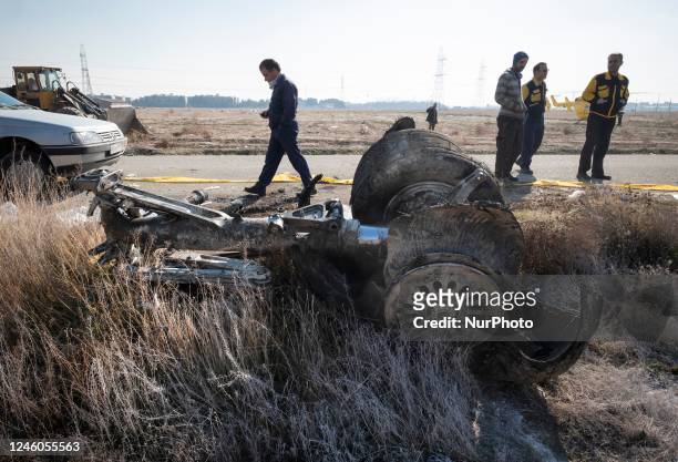 January 8, 2020 file photo shows, An Iranian official walks past a piece of wreckage from the Ukrainian flight PS752 International airlines at the...