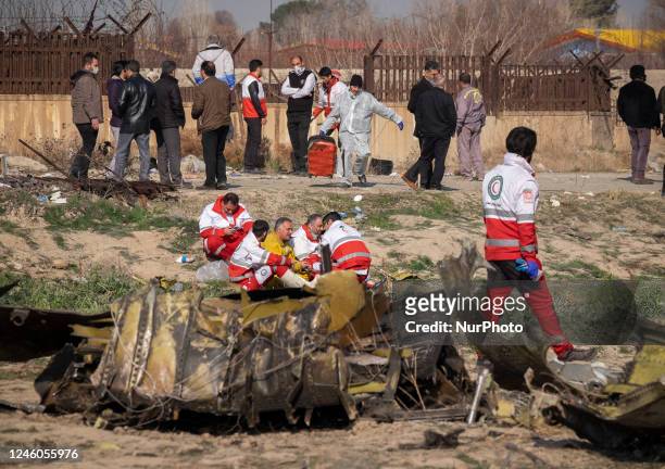 January 8, 2020 file photo shows, Members of the Iranian Red Crescent rest as they sit at the Ukrainian flight PS752 International airlines crash...