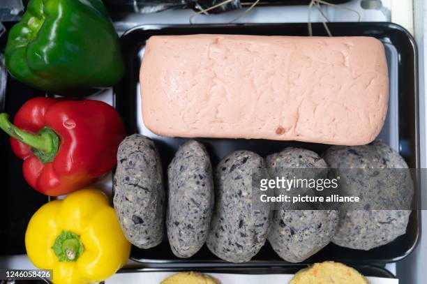 January 2023, Saxony, Dresden: Meatloaf made from seitan and burger patties made from black beans are on display in a "vegan butcher shop" at the new...