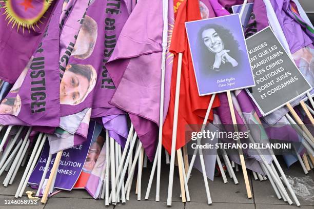 This photograph taken in Paris, on January 7, 2023 shows a portrait of Fidan Dogan among flags during a tribute march in the memory of the three...