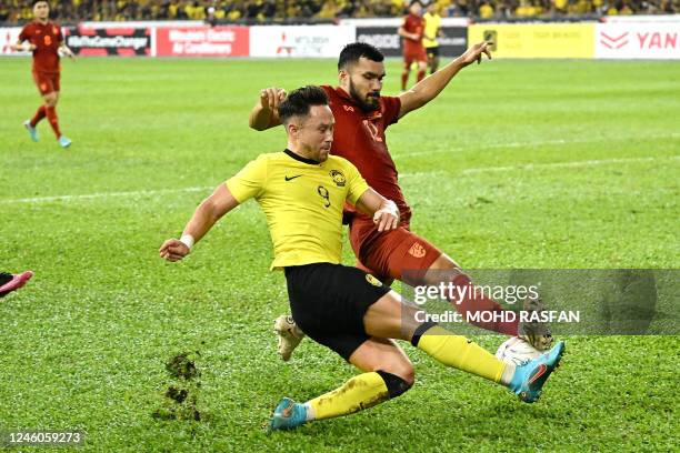 Malaysia's Darren Lock fights for the ball with Thailand's Kritsada Kaman during the AFF Mitsubishi Electric Cup 2022 semi-final football match...