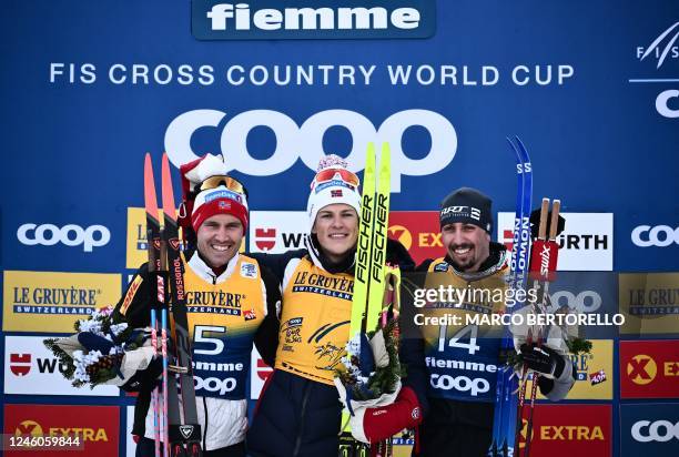 Second-placed Norway's Pal Golberg, race winner Norway's Johannes Hosflot Klaebo and third-placed Italy's Francesco De Fabiani pose after competing...