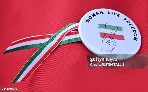 Picture shows a badge that reads 'Woman Life Freedom' worn by a protester dressed as a character from 'A Handmaid's Tale' during a silent protest in...