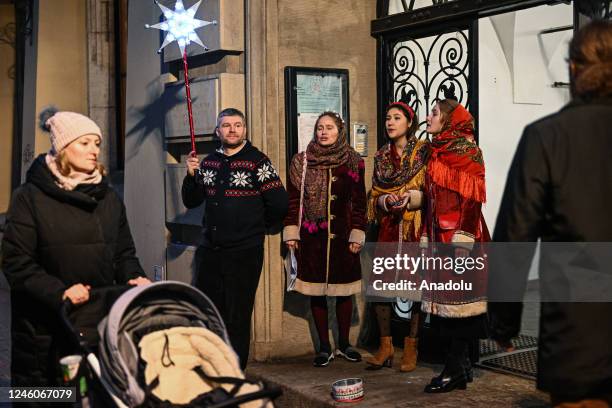 Ukrainians sing Christmas songs by the church door before taking part in the all-night vigil during the Orthodox Christmas at the Orthodox parish of...