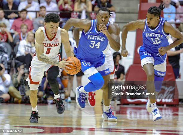 Jahvon Quinerly of the Alabama Crimson Tide and Chris Livingston and Antonio Reeves of the Kentucky Wildcats race after a loose ball during the...