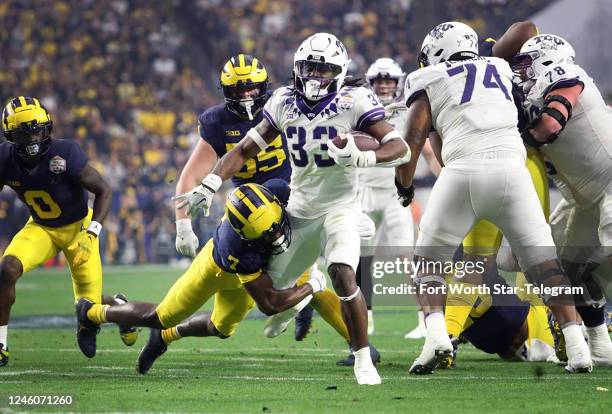 Running back Kendre Miller moves toward the end zone while Michigan safety Makari Paige defends at the Vrbo Fiesta Bowl at State Farm Stadium on Dec....