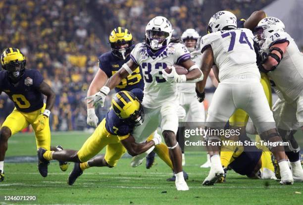 Running back Kendre Miller moves toward the end zone while Michigan safety Makari Paige defends at the Vrbo Fiesta Bowl at State Farm Stadium in...