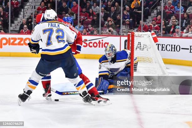 Goaltender Jordan Binnington of the St. Louis Blues pokes the puck away from Josh Anderson of the Montreal Canadiens during the second period of the...