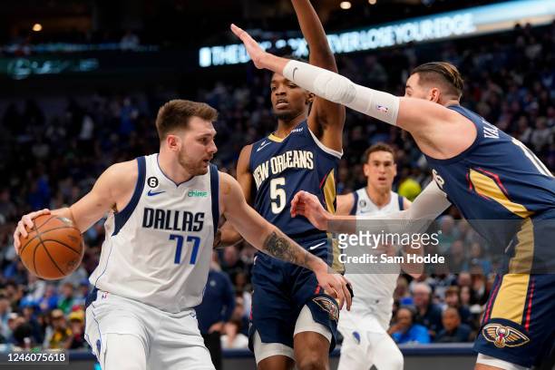 Luka Doncic of the Dallas Mavericks controls the ball as Herbert Jones and Jonas Valanciunas of the New Orleans Pelicans defend during the first half...