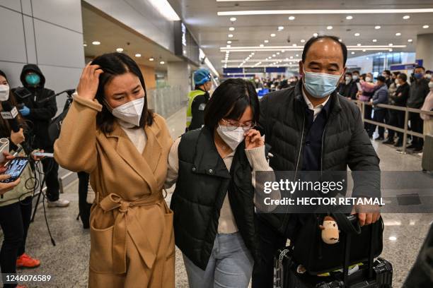 Passenger receives a hug while leaving the arrival area of international flights at the Shanghai Pudong International Airport, in Shanghai on January...