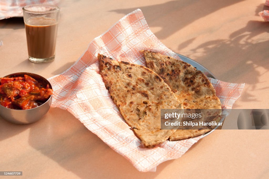 Aloo paratha with achar and chai in morning light