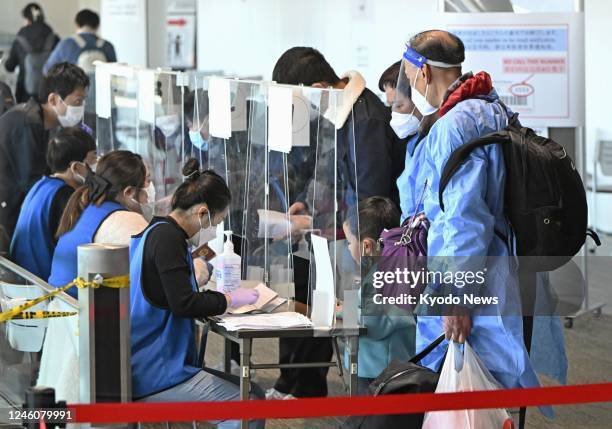 Passengers from Shanghai present proof of a negative COVID-19 test at Narita airport near Tokyo on Jan. 8, 2023. Japan started requiring travelers...