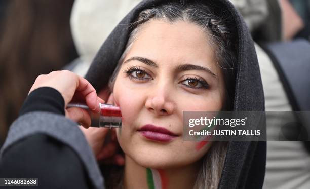 Protester uses face paint at a gathering in central London on January 8, 2023 on the third anniversary of the downing of Ukrainian passenger jet,...