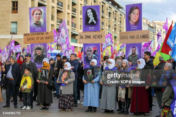 Kurdish protesters hold flags and placards with photos of victims during the demonstration. The Kurdish community of France gathered to pay a tribute...