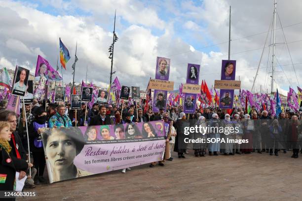 Kurdish protesters hold a banner, flags and placards with photos of victims during the demonstration. The Kurdish community of France gathered to pay...