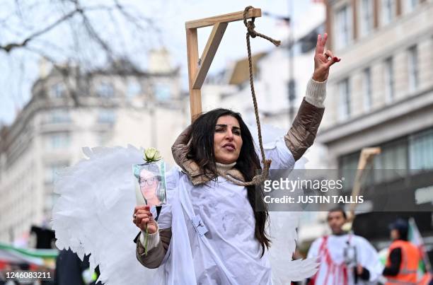 Protesters pose in mock gallows as they gather in central London on January 8, 2023 for a march against the Iranian regime, on the third anniversary...
