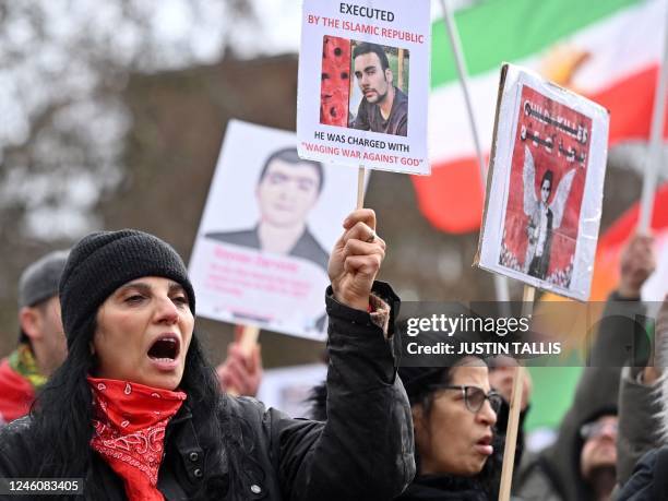 Protesters hold placards as they gather in central London on January 8, 2023 for a march against the Iranian regime, on the third anniversary of the...