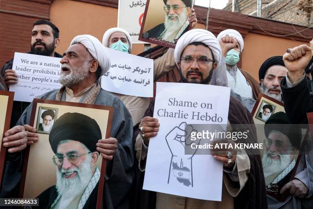 Demonstrators gather with images of Iran's supreme leader Ayatollah Ali Khamenei during a protest against defamatory cartoons depicting him published...