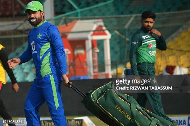 Pakistan's Mohammad Rizwan arrives to attend a training session as his team captain Babar Azam watches ahead of their one day international cricket...