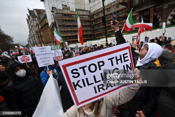 Protesters hold placards at a march in central London on January 8, 2023 against the Iranian regime, on the third anniversary of the downing of...