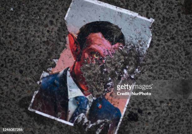 Torn caricature of the French President Emmanuel Macron is pictured on a street in front of the France embassy during a protest gathering against the...