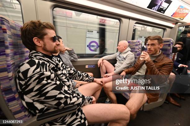 People take part in the annual 'No Trousers On The Tube Day' on the Elizabeth Line, on the London Underground in central London on January 8, 2023. -...