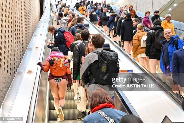 People take part in the annual 'No Trousers On The Tube Day' on the London Underground in central London on January 8, 2023. - 2023 sees the 12th...