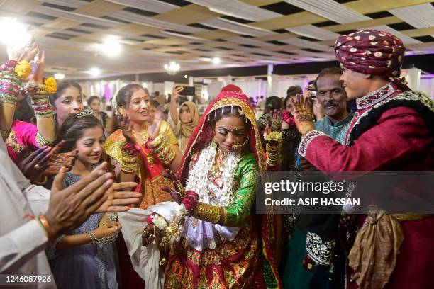 Pakistani Hindu couple dances during a mass wedding ceremony in Karachi on January 8, 2023.