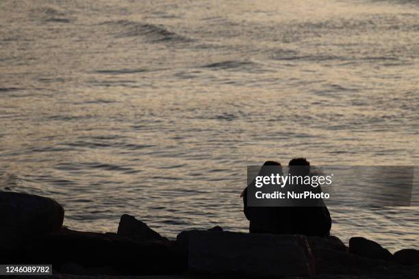 Couple sit on a seashore in Tel Aviv, Israel on December 30, 2022.