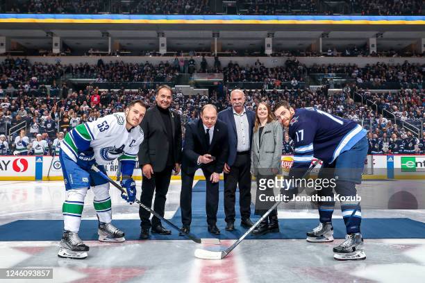 Bo Horvat of the Vancouver Canucks and Adam Lowry of the Winnipeg Jets take part in the ceremonial puck drop prior to NHL action at the Canada Life...