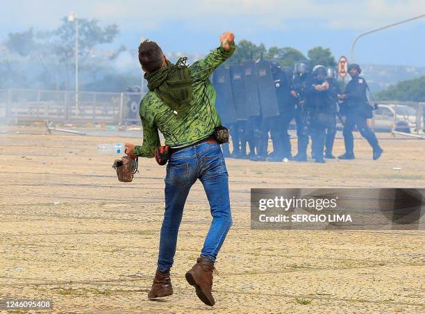 Supporter of Brazilian former President Jair Bolsonaro throws stones at security forces during clashes outside Planalto Presidential Palace in...