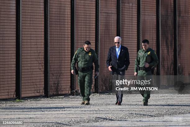 President Joe Biden speaks with a member of the US Border Patrol as they walk along the US-Mexico border fence in El Paso, Texas, on January 8, 2023....