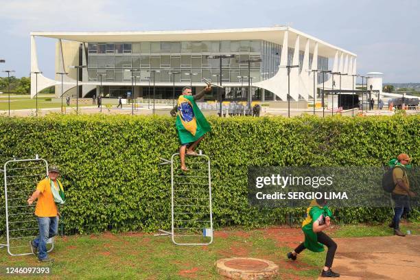 Supporters of Brazilian former President Jair Bolsonaro clash with riot police at Planalto Presidential Palace in Brasilia on January 8, 2023. -...