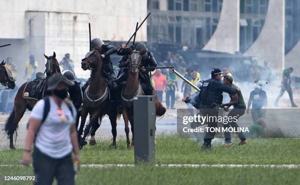 Supporters of Brazilian former President Jair Bolsonaro clash with security forces during an invasion to Planalto Presidential Palace in Brasilia on...