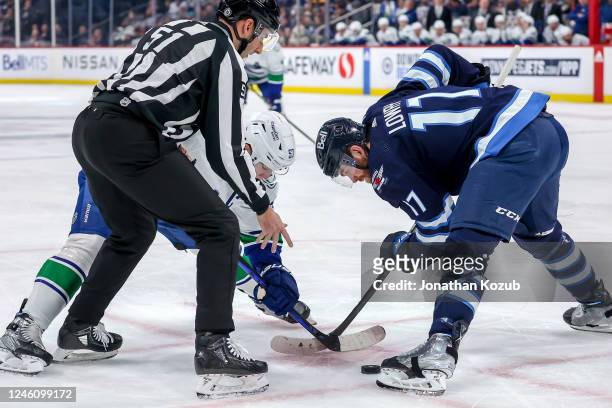 Adam Lowry of the Winnipeg Jets wins a first period face-off against Bo Horvat of the Vancouver Canucks at the Canada Life Centre on January 8, 2023...