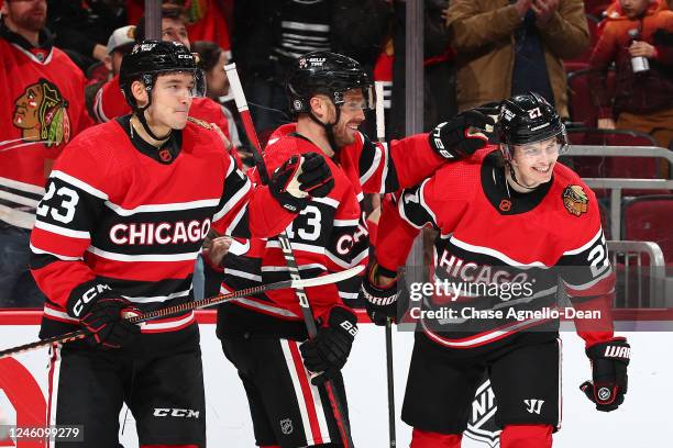 Philipp Kurashev, Max Domi and Lukas Reichel of the Chicago Blackhawks celebrate after Kurashev scores against the Calgary Flames in the second...